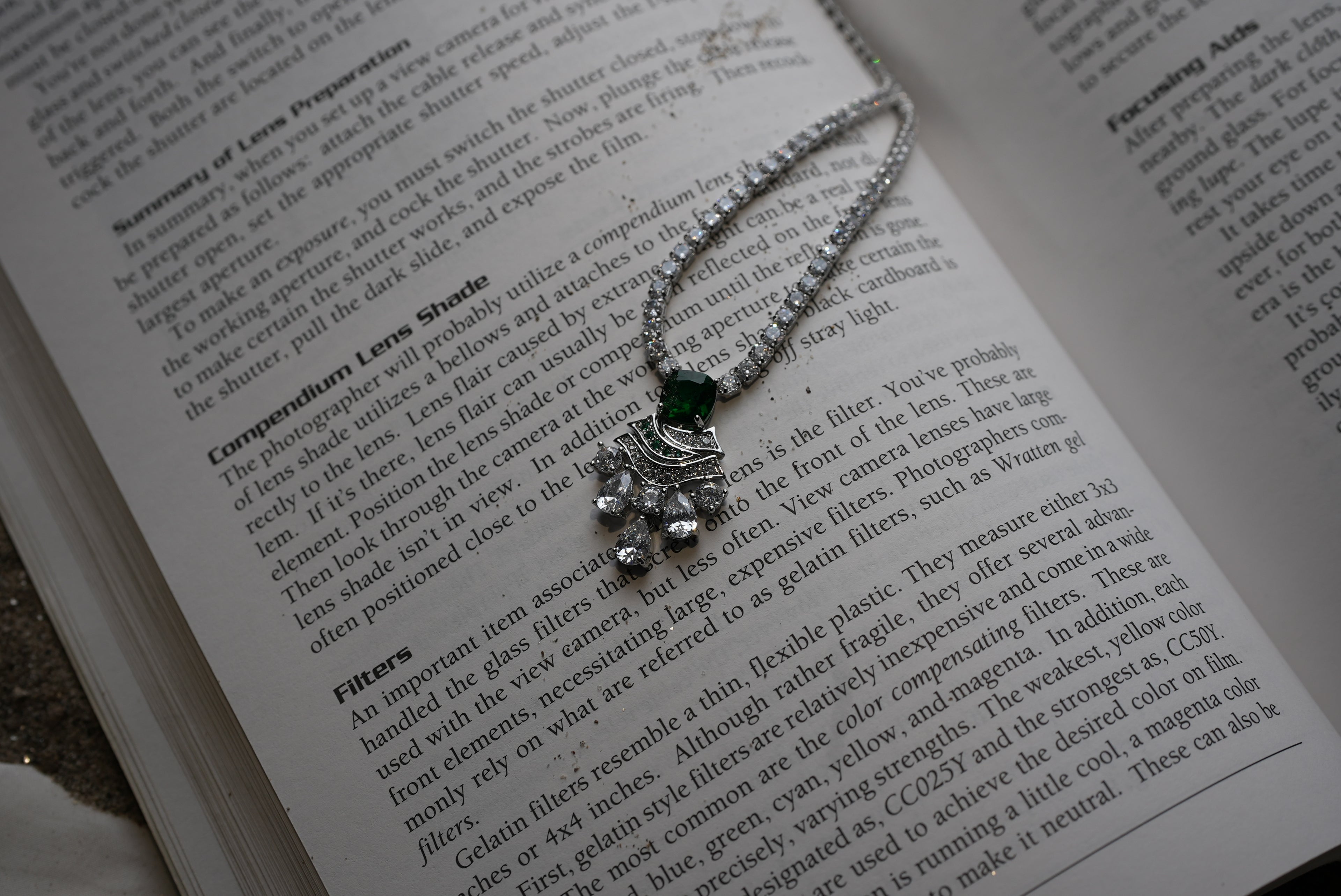 Necklace with a green gemstone on an open book