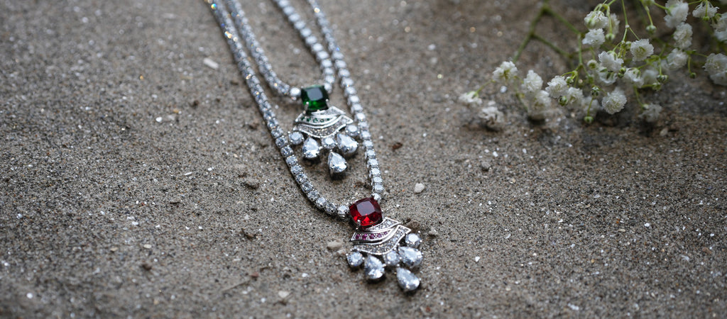 Silver necklace with pendants on a sandy surface
