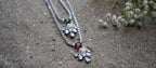 Silver necklace with pendants on a sandy surface
