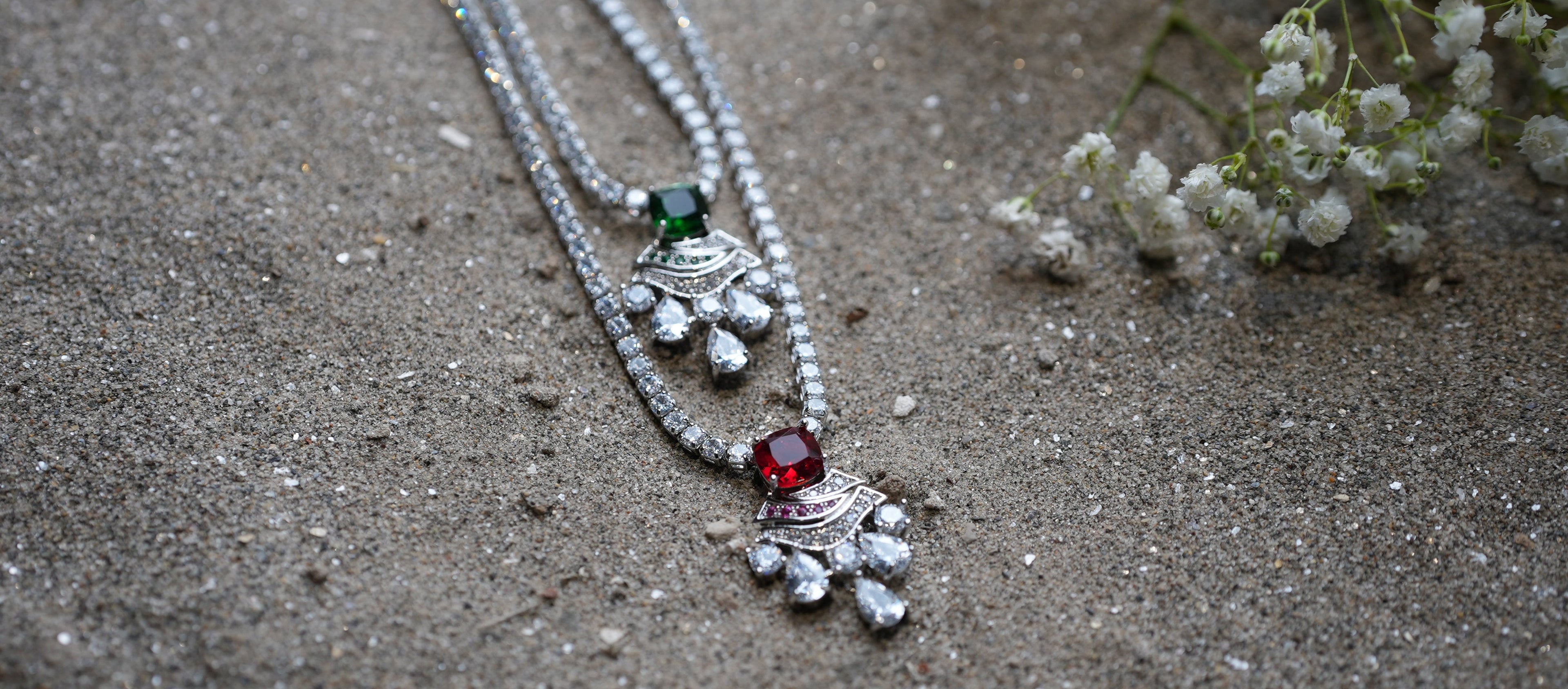 Silver necklace with pendants on a sandy surface
