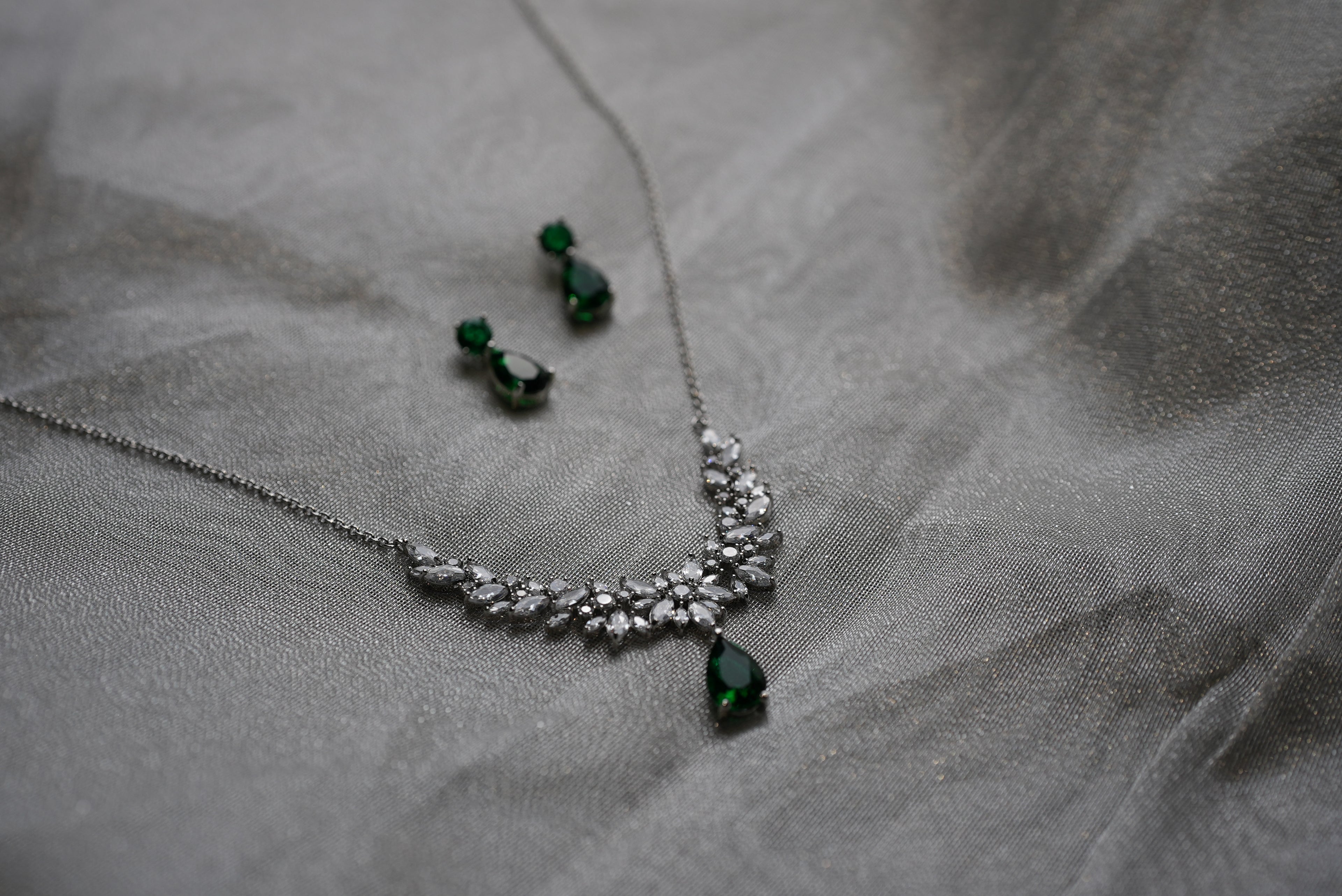 Jewelry set with necklace and earrings on a gray fabric background